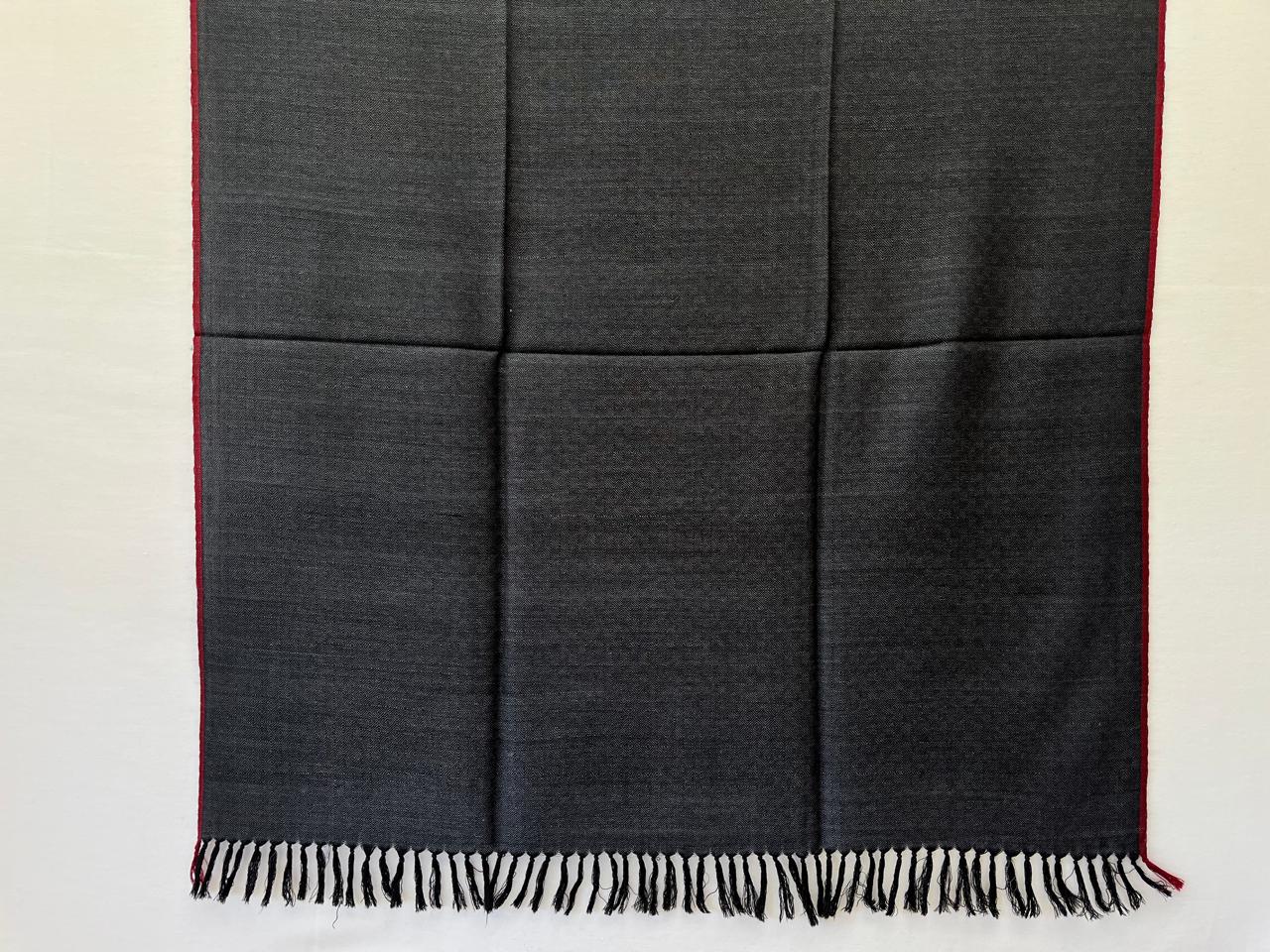 Handwoven merino wool shawl in black with white weft and a thin red selvedge