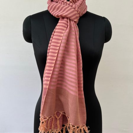 Hand woven cotton stole in a background of blush red with an overlay of ruby red stripes. Knotted on a mannequin.