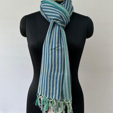 Hand woven cotton stole with one inch stripes in two vertical bands. One half with navy bllue stripes and the other with arctic blue stripes. On a silver background. Knotted on a mannequin.