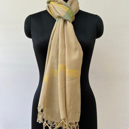 Hand woven cotton stole in cream with asymmetric checks in teal green and honey yellow. Knotted on a mannequin.