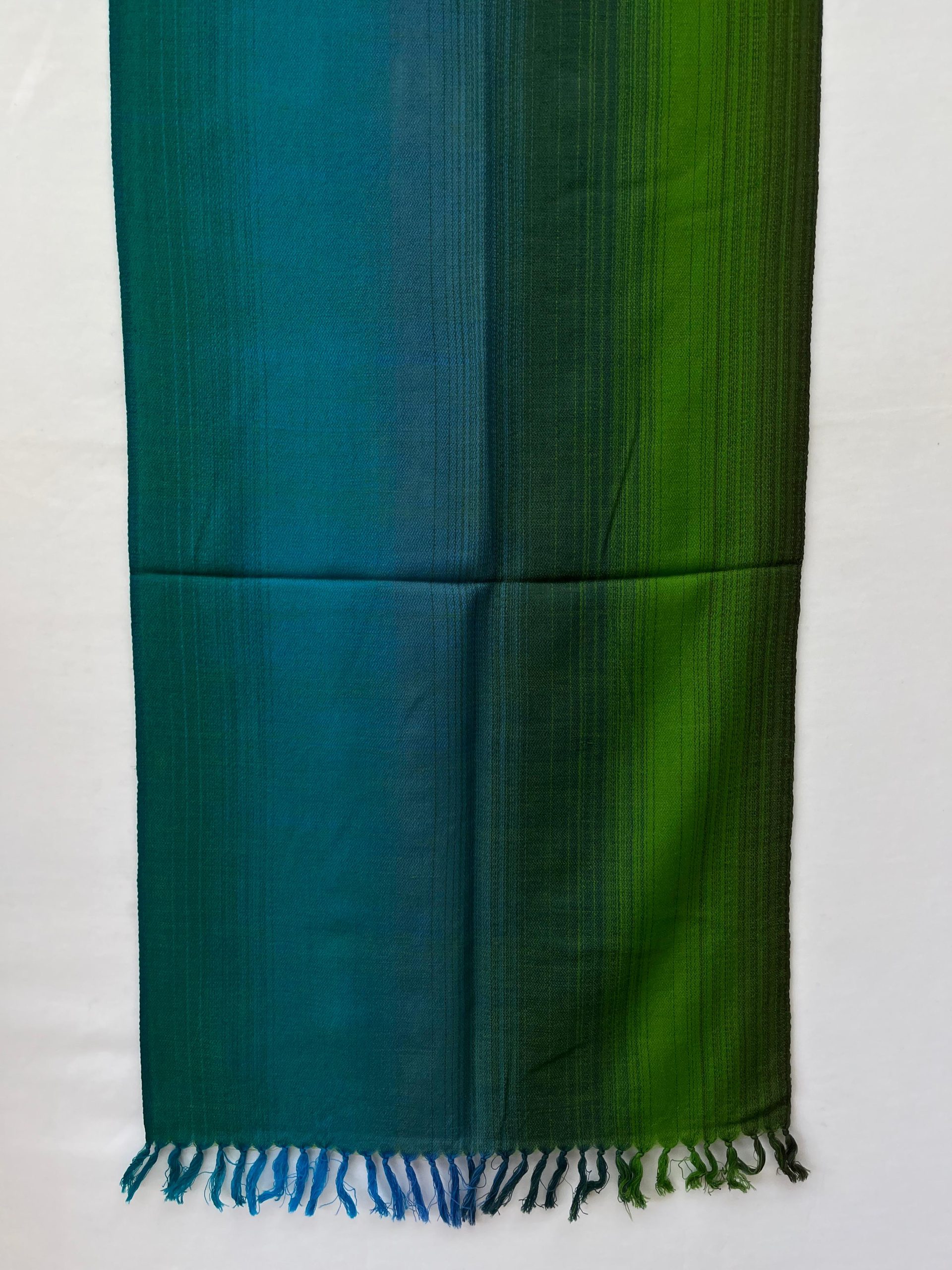 Ombre hand woven merino wool stole in gradation of teal blue, deep cerulean, burdock green and pine.