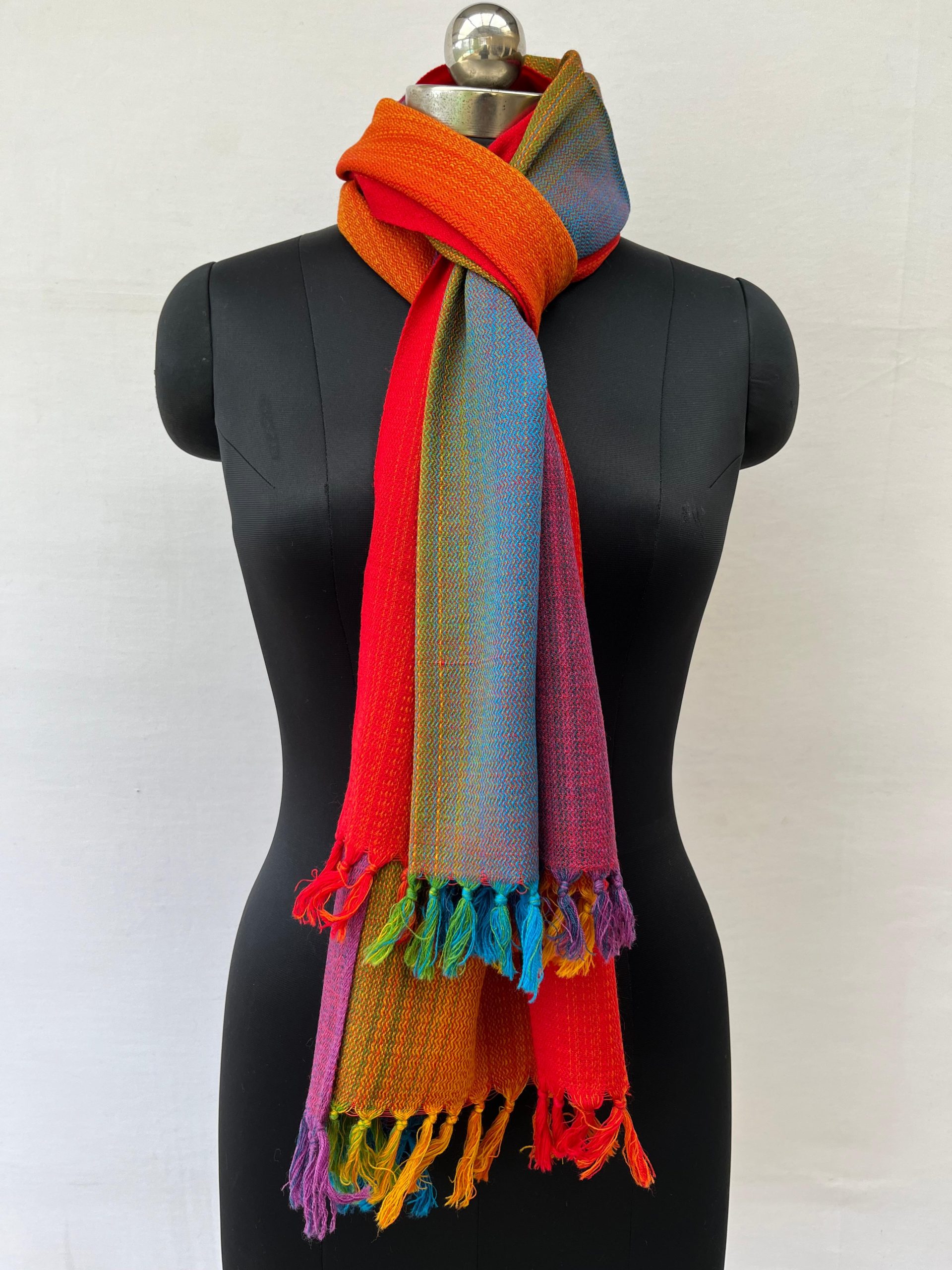 Ombre hand-woven merino wool stole that starts with amethyst, goes into purple, blue, green hint of yellow, orange and red. Knitted on a mannequin.