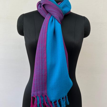 Ombre hand woven merino wool stole in blue, teal and plum. Knotted on a mannequin.