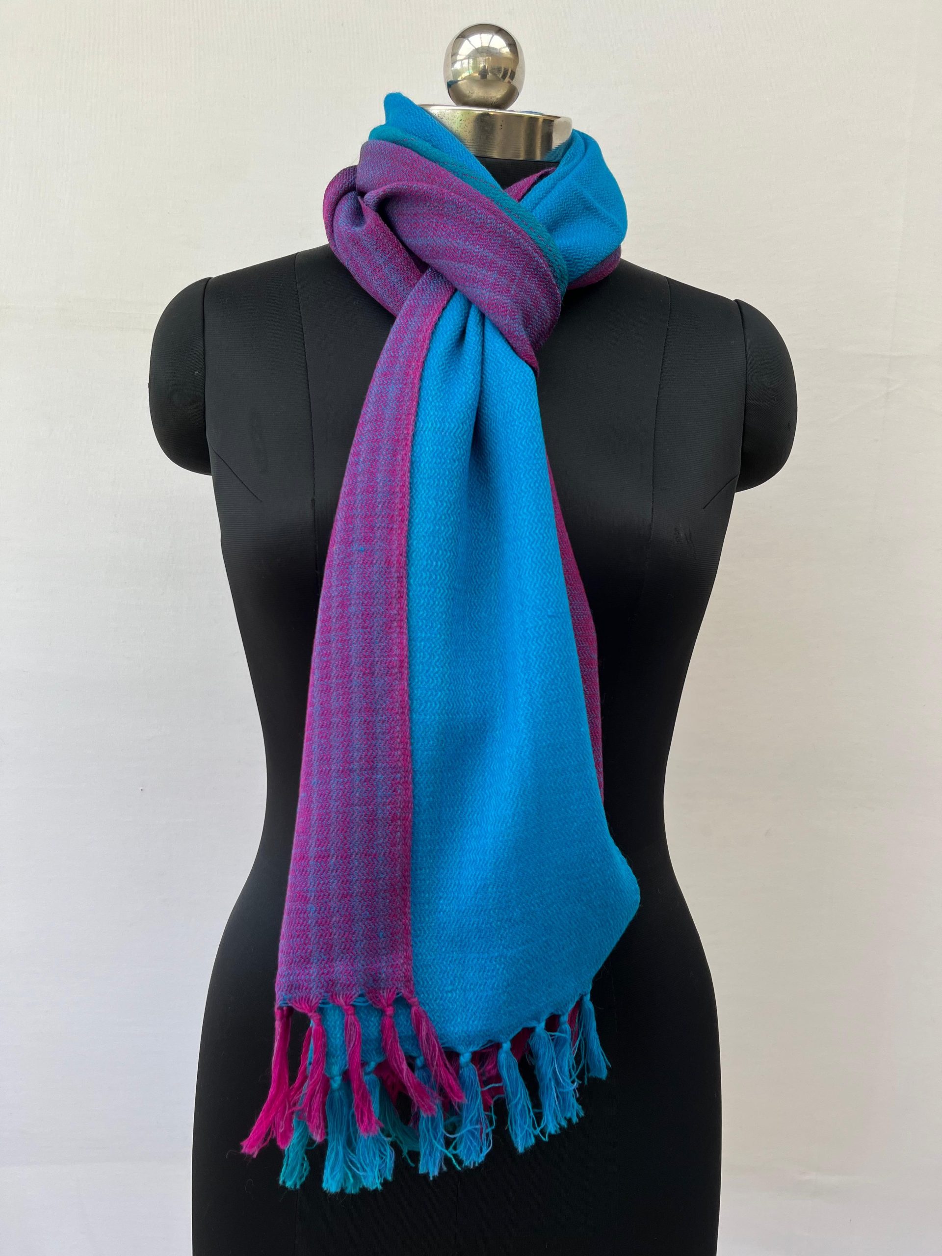 Ombre hand woven merino wool stole in blue, teal and plum. Knotted on a mannequin.