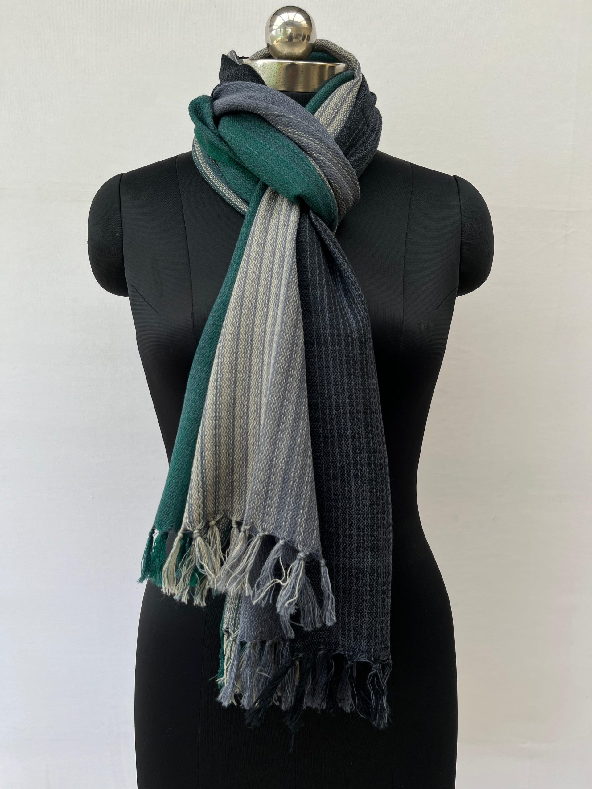 Ombre hand woven merino wool stole in shades of navy, mauve, charcoal, silver and deep teal.Knotted on a mannequin.
