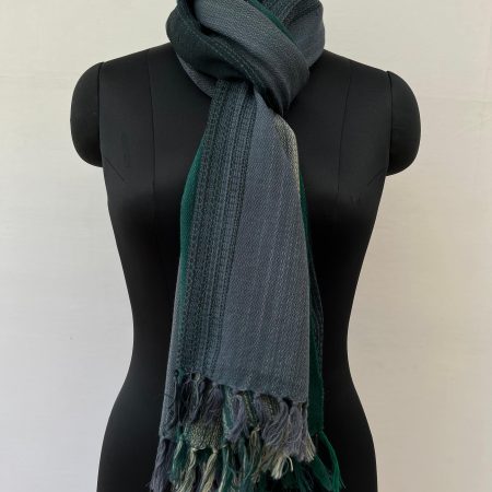 Ombre hand woven merino wool stole in deep forest green, silver, and charcoal. Knotted on a mannequin.