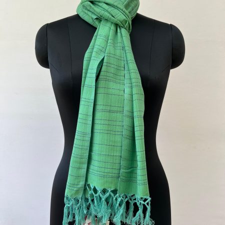 Hand woven cotton stole in apple green with irregular horizontal stripes in navy blue. Knotted on a mannequin.