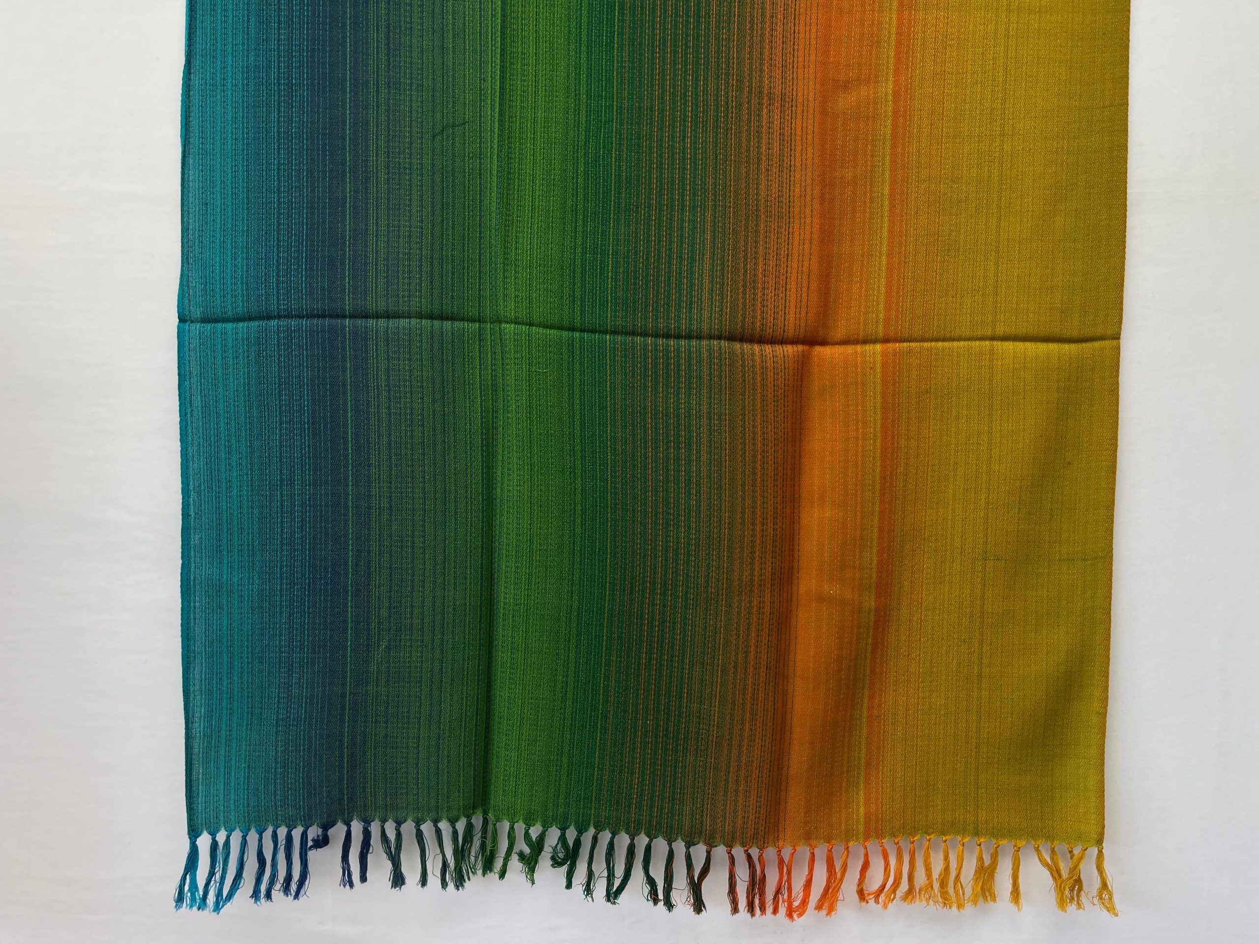 Ombre handwoven merino wool shawl in shades ranging from forest green, pine green, marigold to ochre.