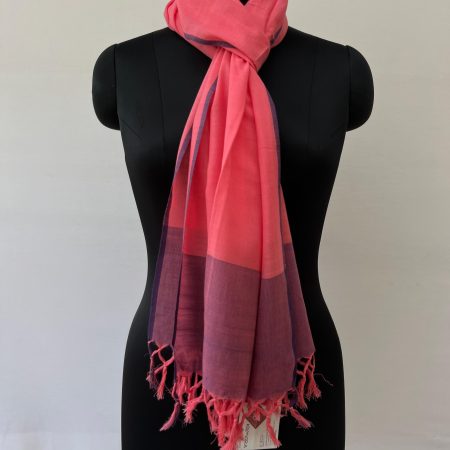 Hand-woven cotton stole in a deep pink, with a thin navy blue edging on both sides and a navy blue border. Knotted on a mannequin.