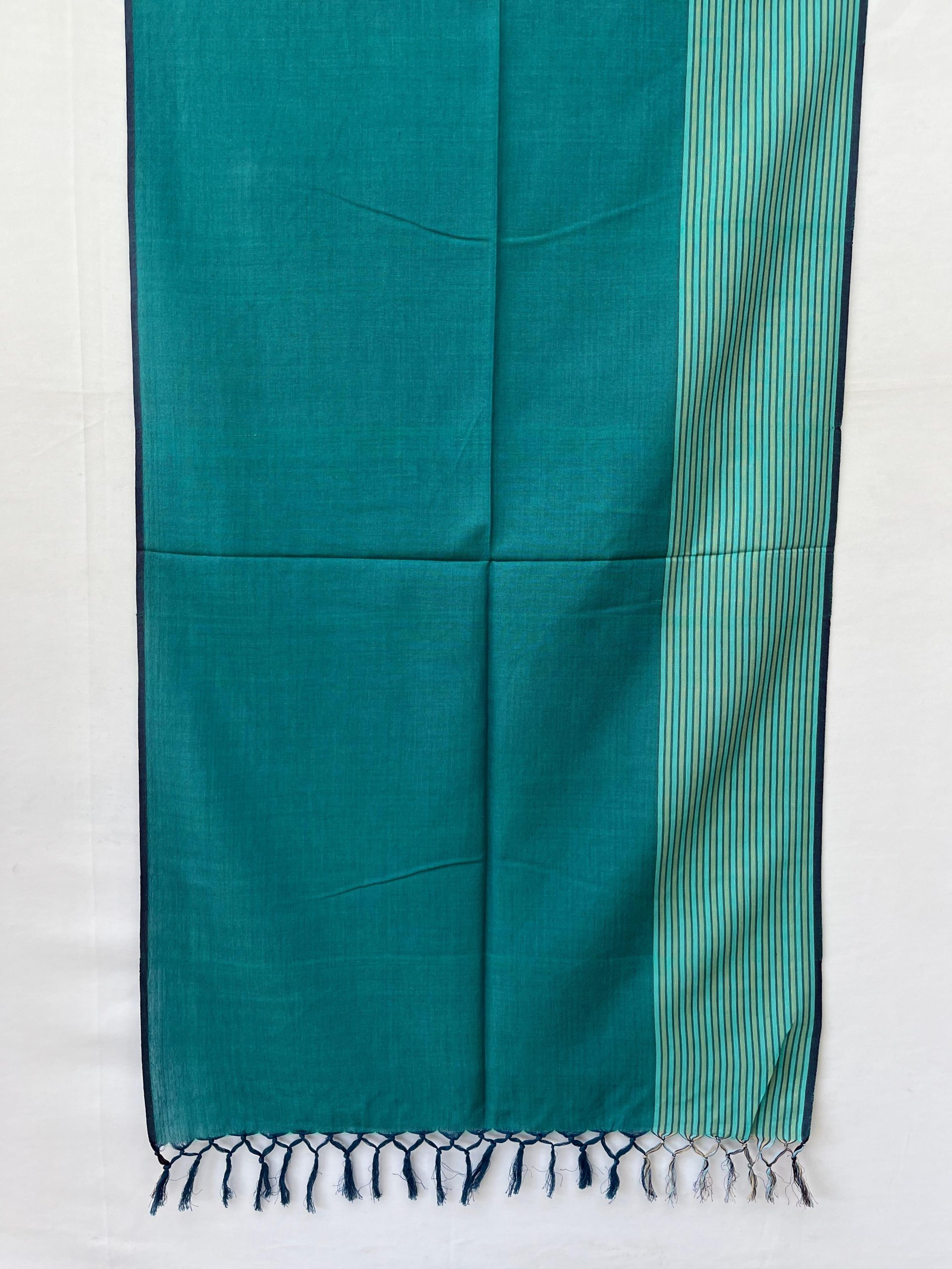 Hand-woven cotton stole in a deep teal with a striped teal and sea foam green vertical border on one side of the stole.