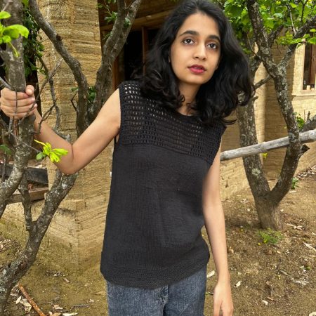 Model is wearing a hand-knit cotton jaali top in black