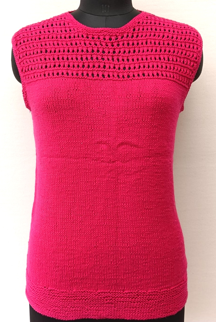 Mannequin is wearing a hand-knit cotton jaali top in magenta
