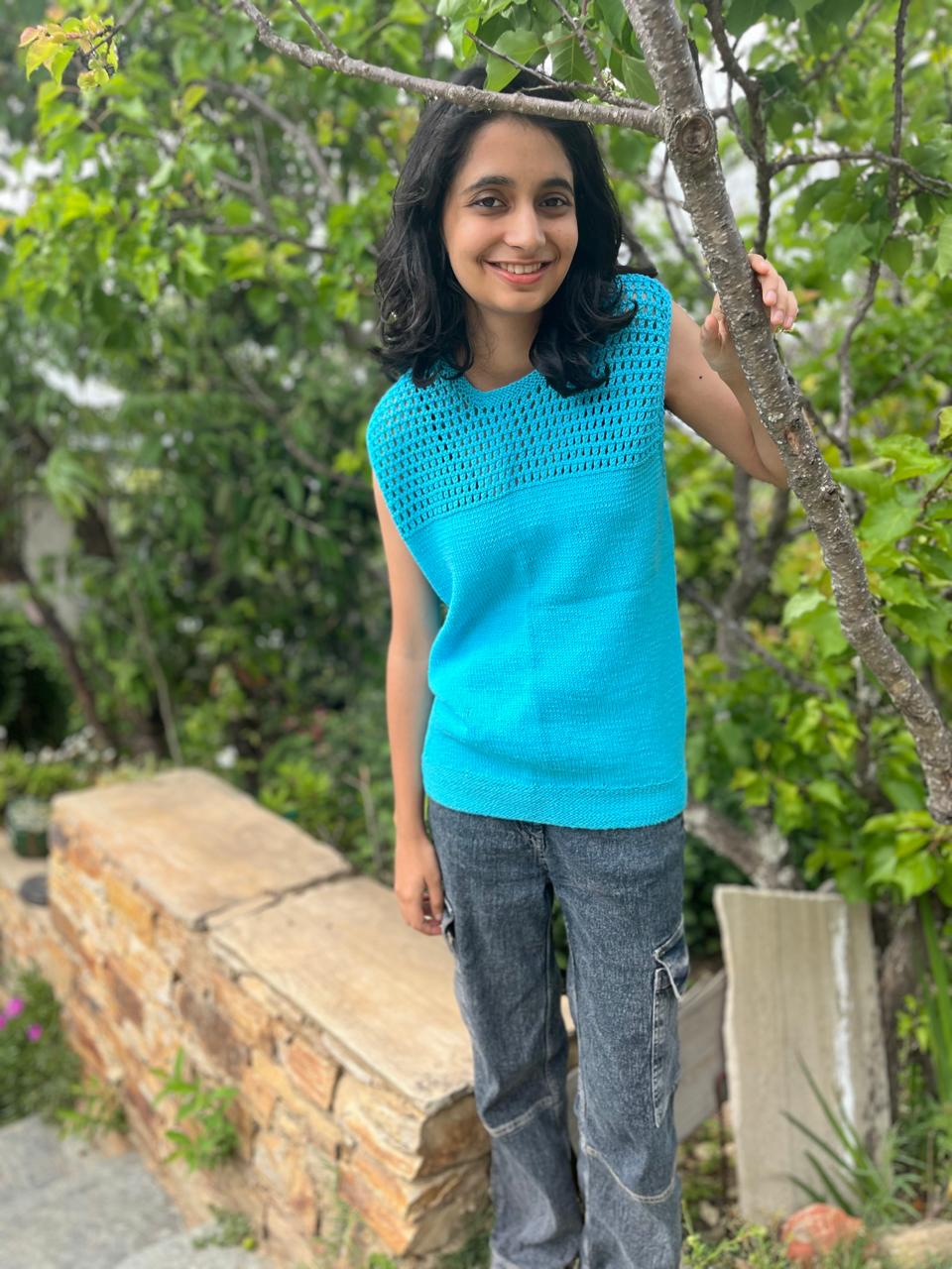 Model is wearing a hand-knit cotton jaali top in sky blue