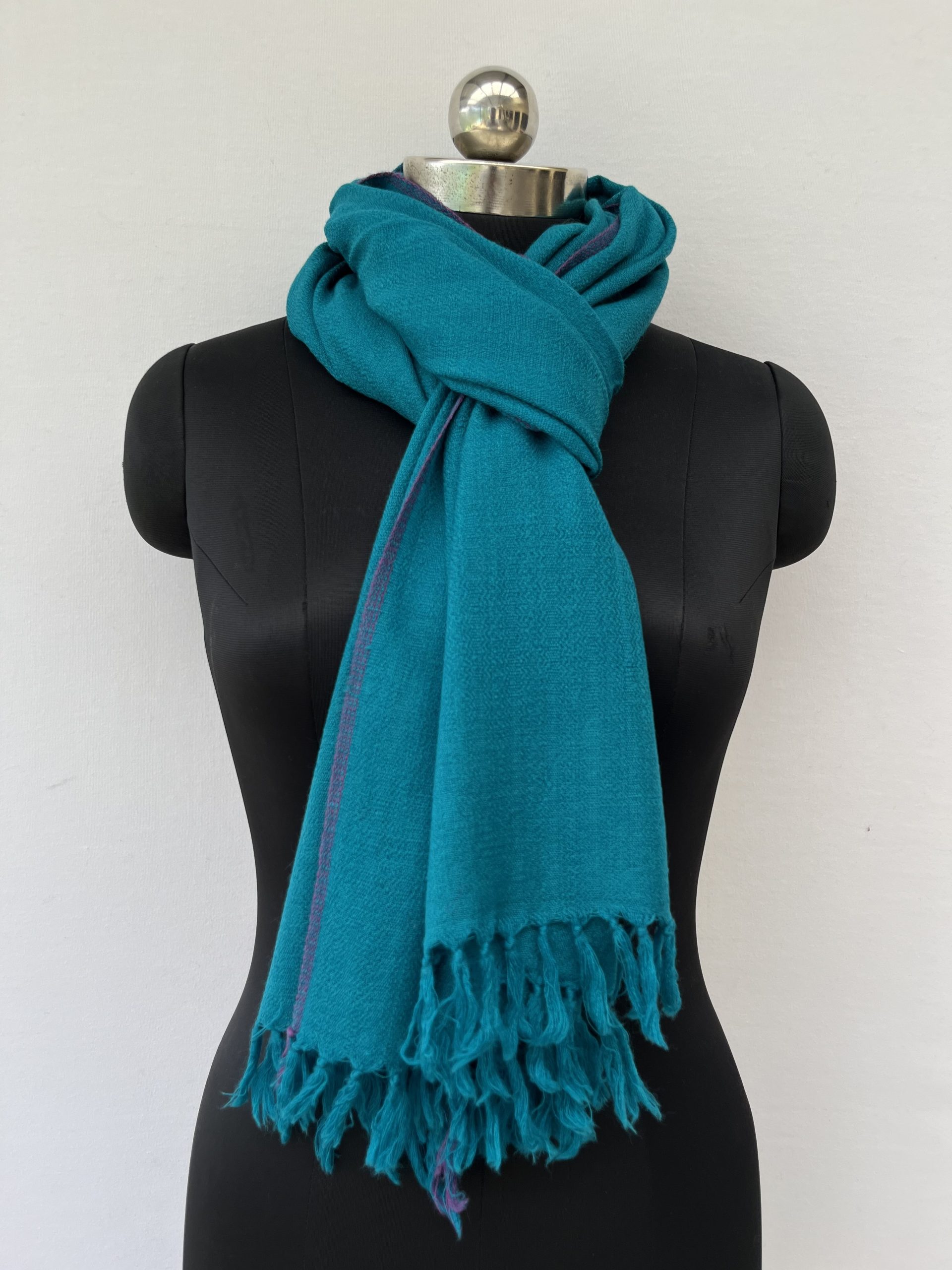 Hand-woven merino wool stole in cerulean blue with a thin purple selvedge.