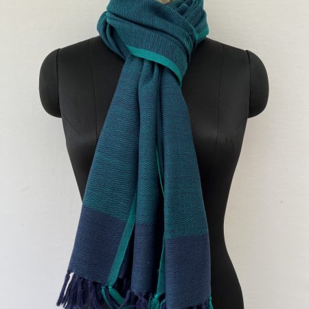 Hand-woven merino wool stole in peacock blue with a teal selvedge.
