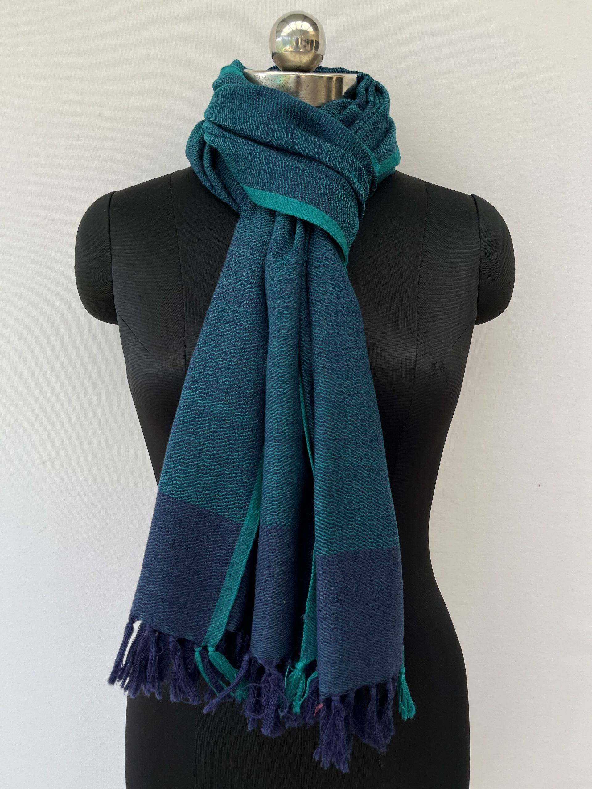 Hand-woven merino wool stole in peacock blue with a teal selvedge.