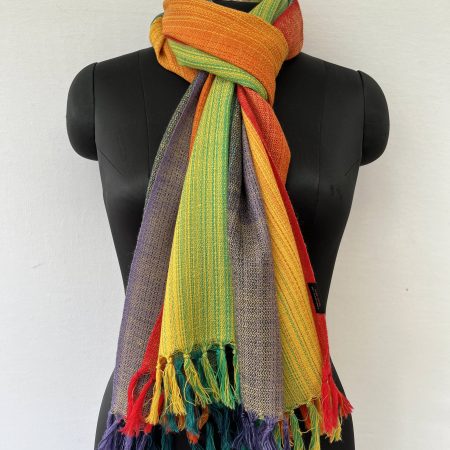 Hand-woven merino wool stole in rainbow color paletter ranging from violet at one end and ending with red on the other in an ombre weave.