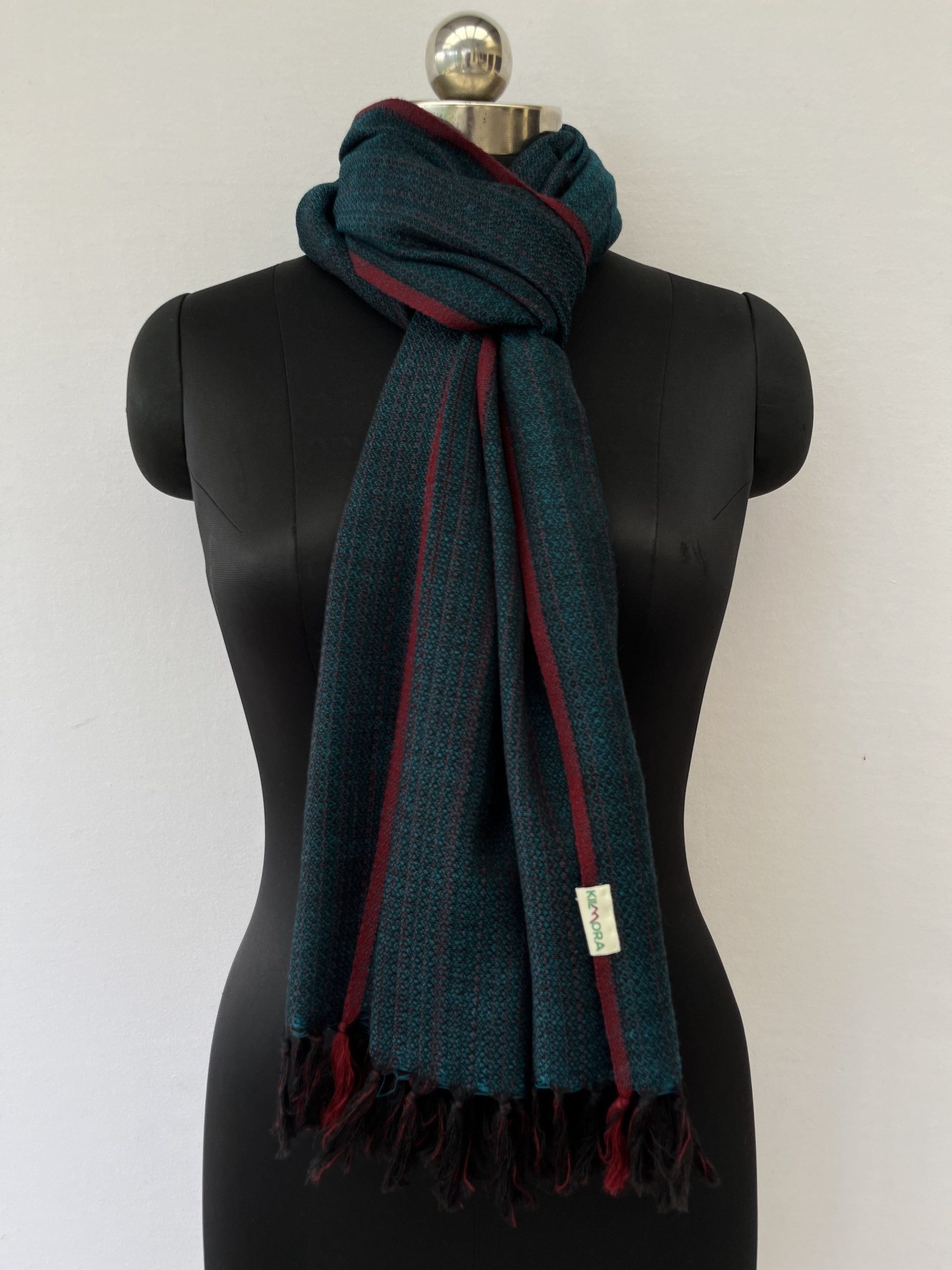 Hand-woven merino wool stole in peacock blue with red selvedge, and red stripes interwoven throughtout the stole.