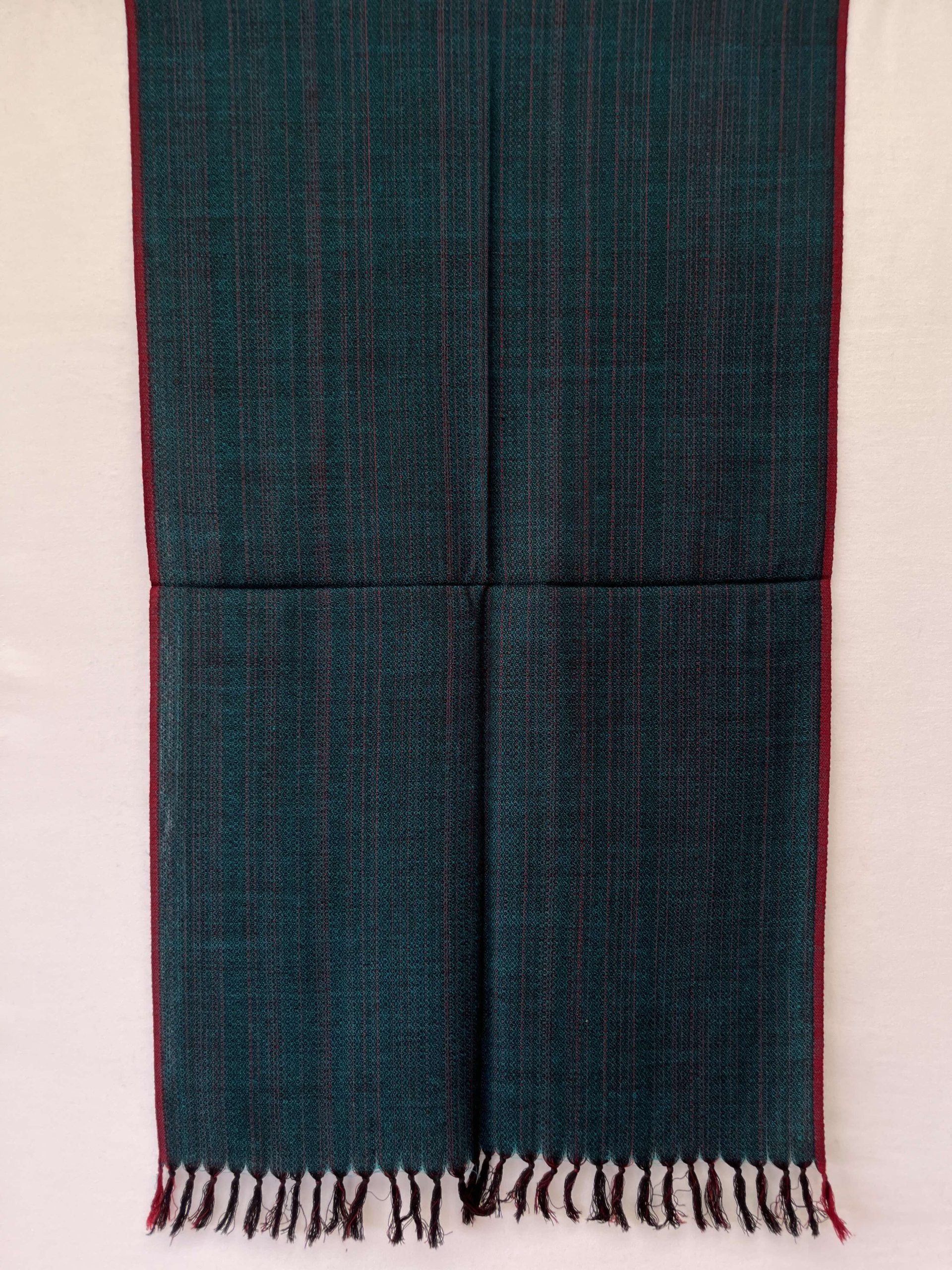 Hand-woven merino wool stole in peacock blue with red selvedge, and red stripes interwoven throughtout the stole.
