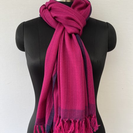 Hand-woven merino wool stole in pink with striated navy blue within the stole and a navy blue selvedge.