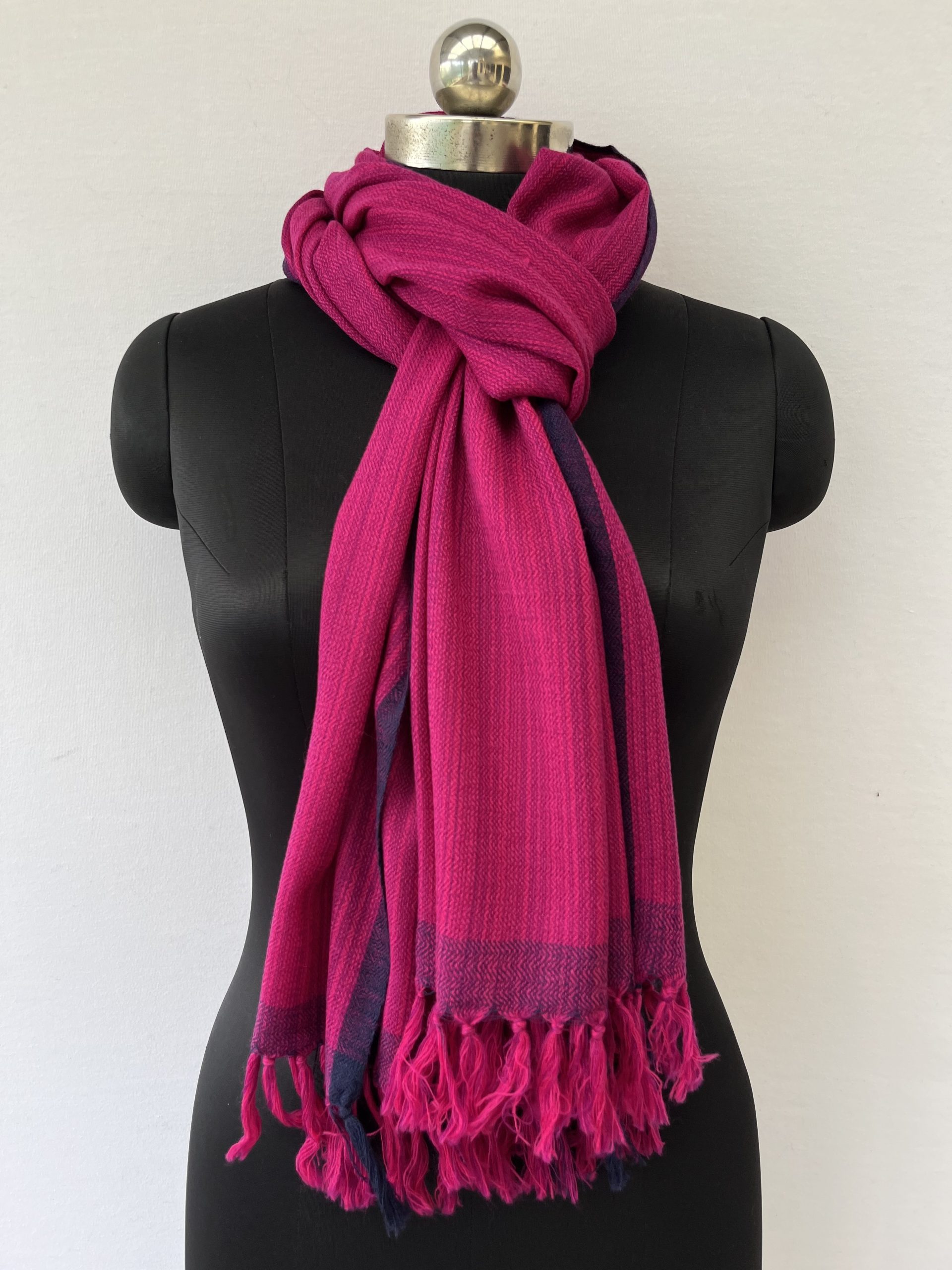 Hand-woven merino wool stole in pink with striated navy blue within the stole and a navy blue selvedge.