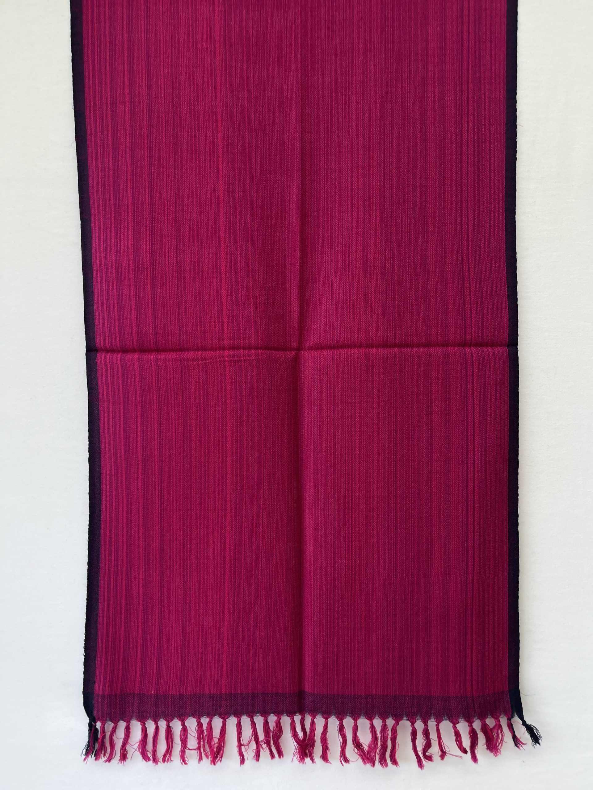 Hand-woven merino wool stole in pink with striated navy blue within the stole and a navy blue selvedge.